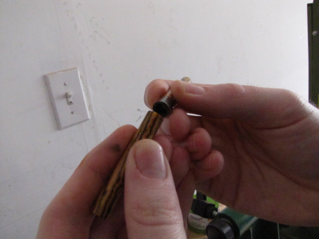 hold one end of your finished barrel firmly, and push the glued bushing hard to one side